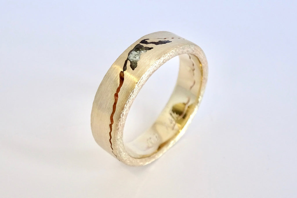 Close-up of 14k yellow gold Rainer Summit Mountain Ring highlighting textured metal edges and hand-cut mountain peak esign.