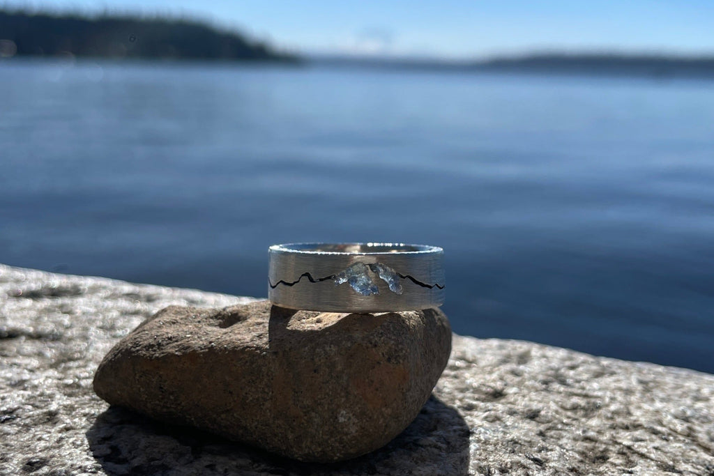 Close-up of Rainier Summit ring featuring sapphire inlay and detailed mountain silhouette design.