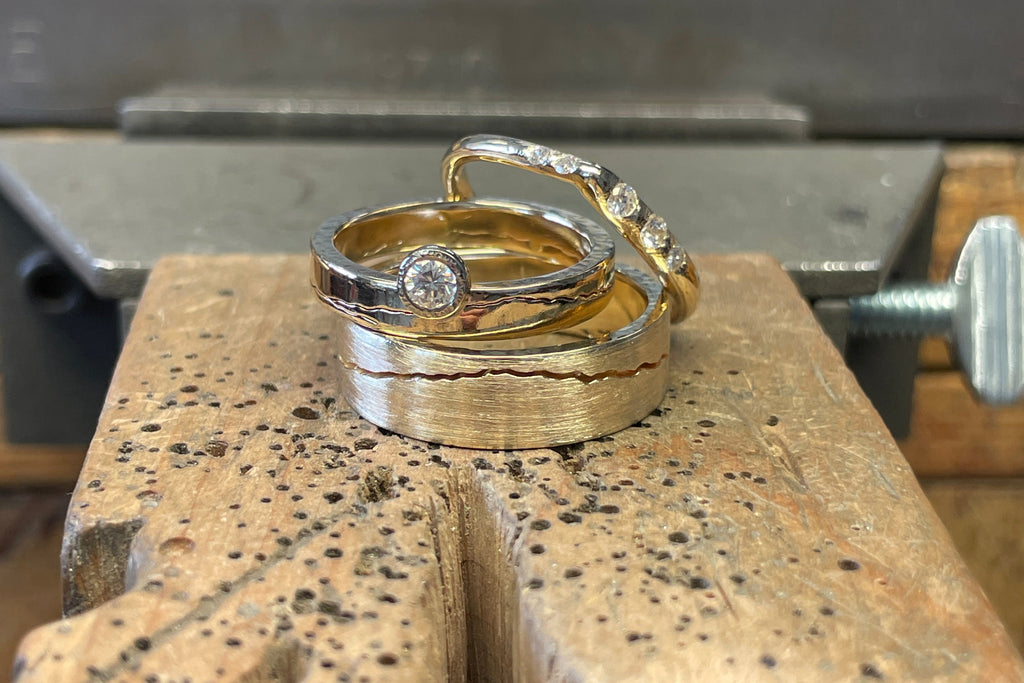 Handmade mountain wedding band in 14k yellow gold.  Shown with a diamond moon mountain wedding band and a diamond peak band.  All handcrafted with recycled yellow gold 
